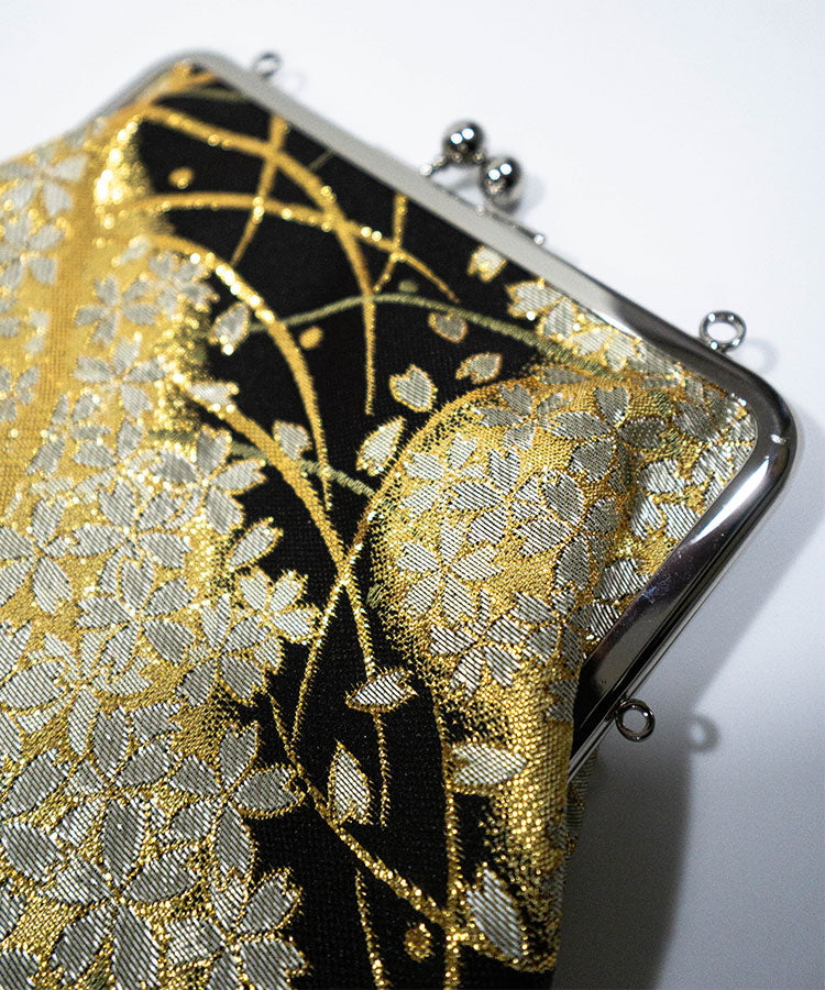 Close-up detail of black and gold Kinran fabric Japanese shoulder gamaguchi bag