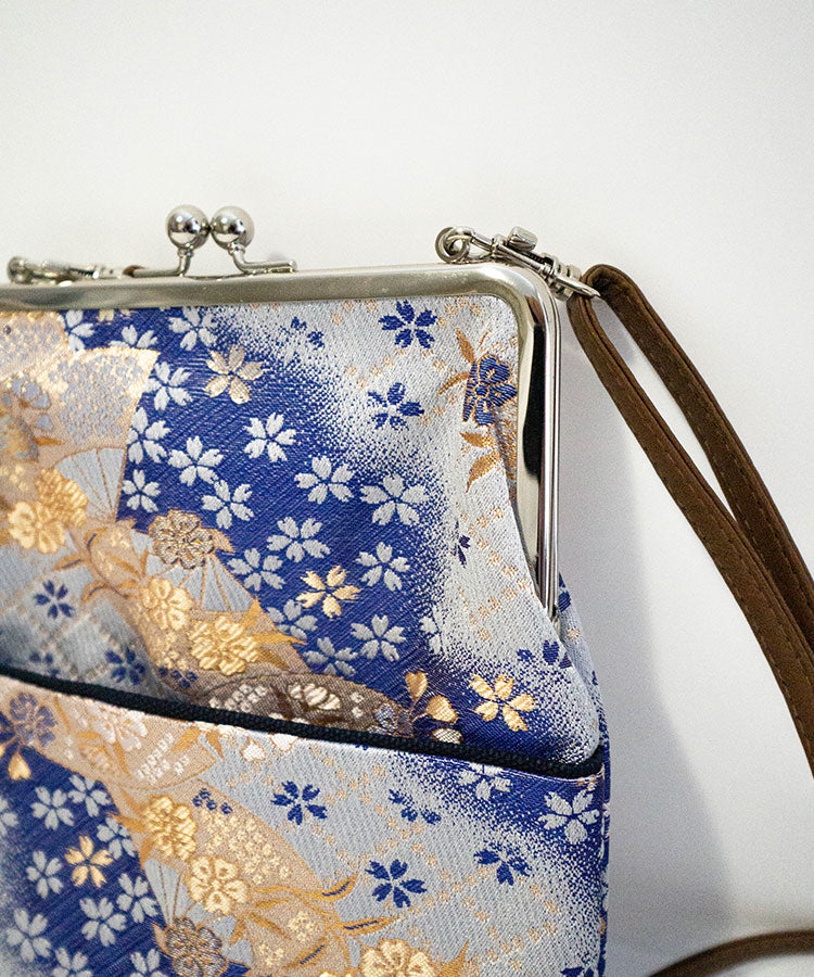 Floral patterned handbag with a strap on a white background