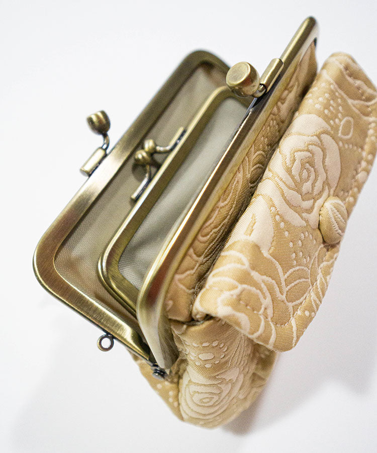 Decorative clutch with gold frame and floral pattern on a white background