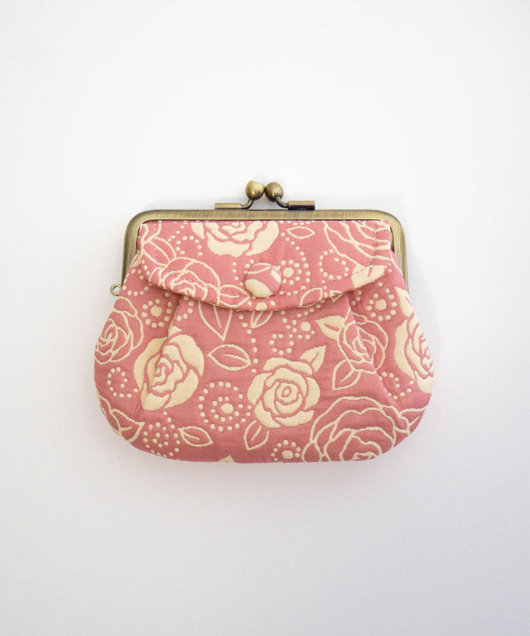 Small pink gamaguchi coin purse with rose pattern on a white background