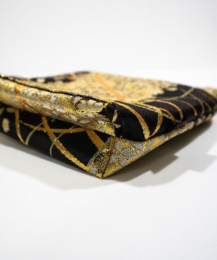Black and gold patterned pouch on a white background