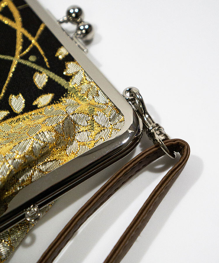Gold and black clutch bag with a strap on a white background