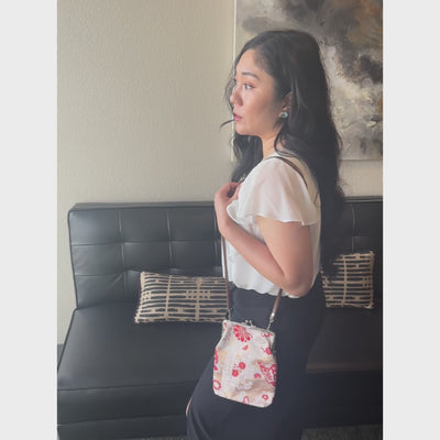Crimson Butterfly kinran fabric shoulder gamaguchi bag with red floral and butterfly pattern shown in motion
