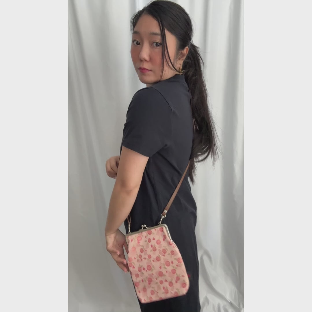 Blossom Whisper kinran fabric shoulder gamaguchi bag with pink rose pattern shown in motion