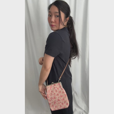 Blossom Whisper kinran fabric shoulder gamaguchi bag with pink rose pattern shown in motion