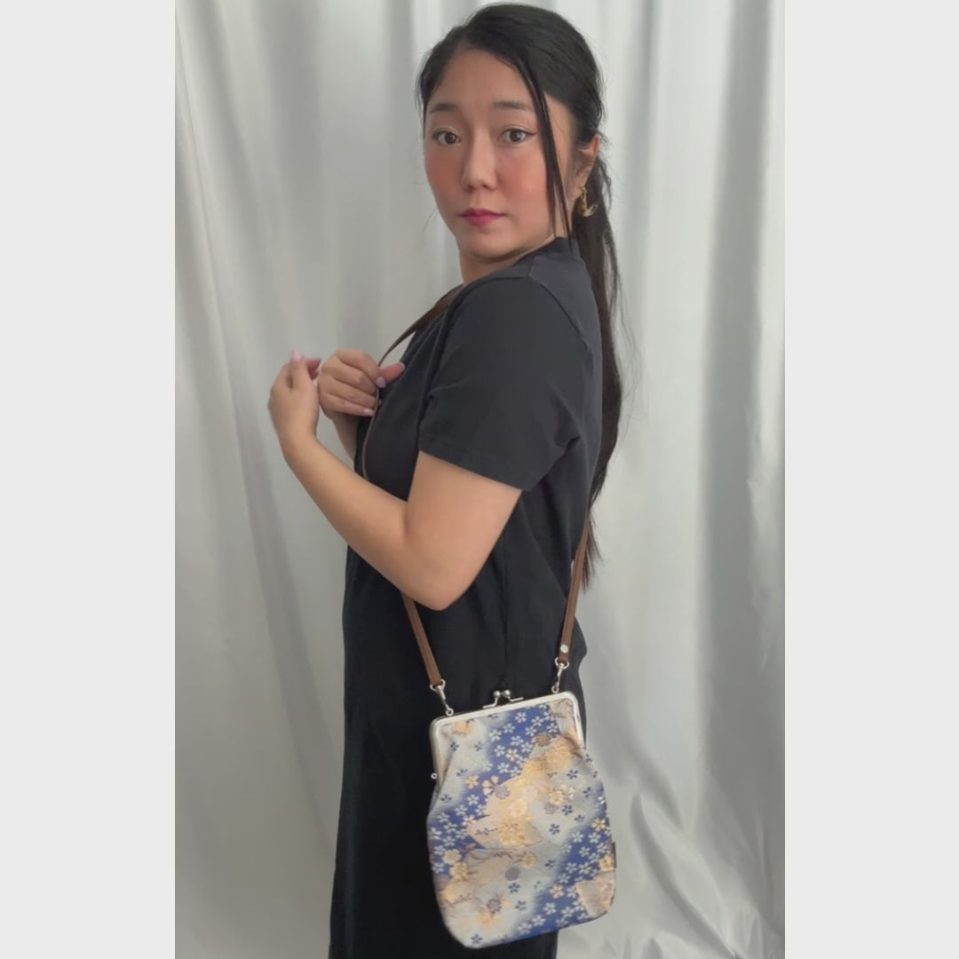 Azure Festival kinran fabric shoulder gamaguchi bag with blue and gold fan floral pattern shown in motion