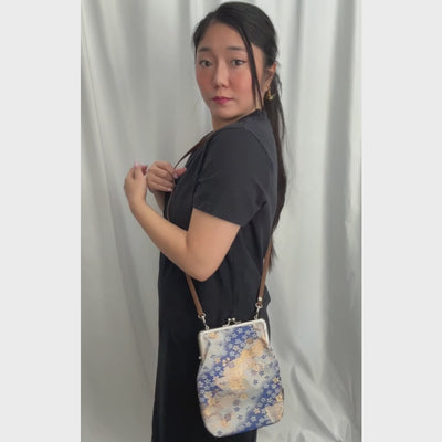 Azure Festival kinran fabric shoulder gamaguchi bag with blue and gold fan floral pattern shown in motion